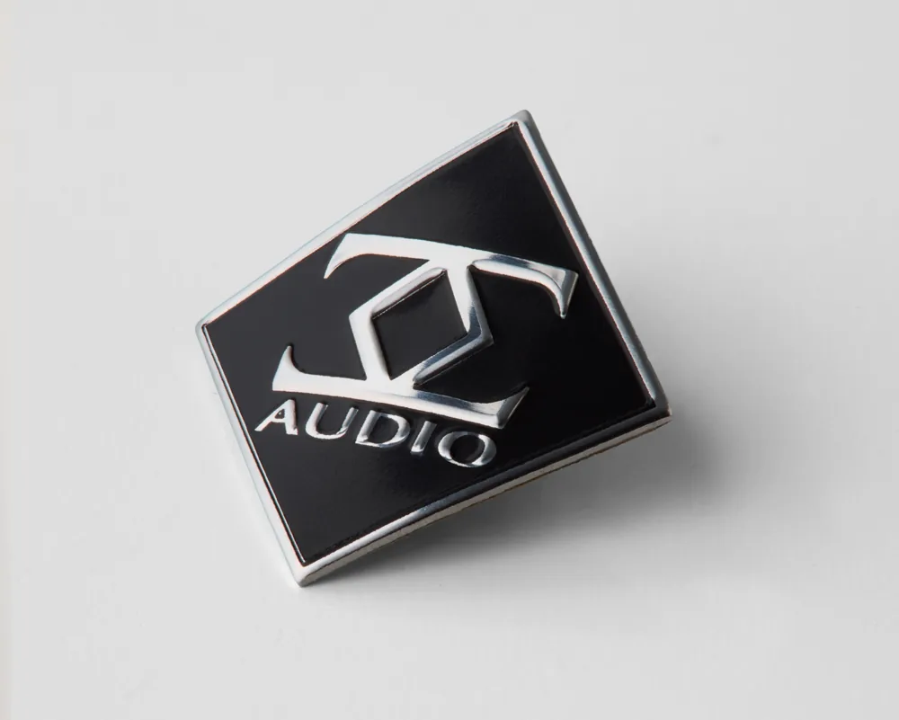 Black and aluminum audio logo badge