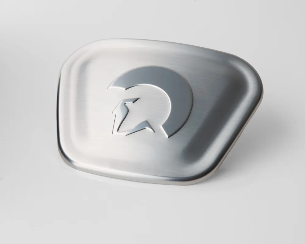 Aluminum badge with embossed helmet logo